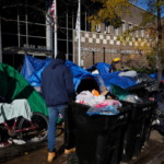 Migrants desperately digging through trash bins for food as they live out of buses in Chicago